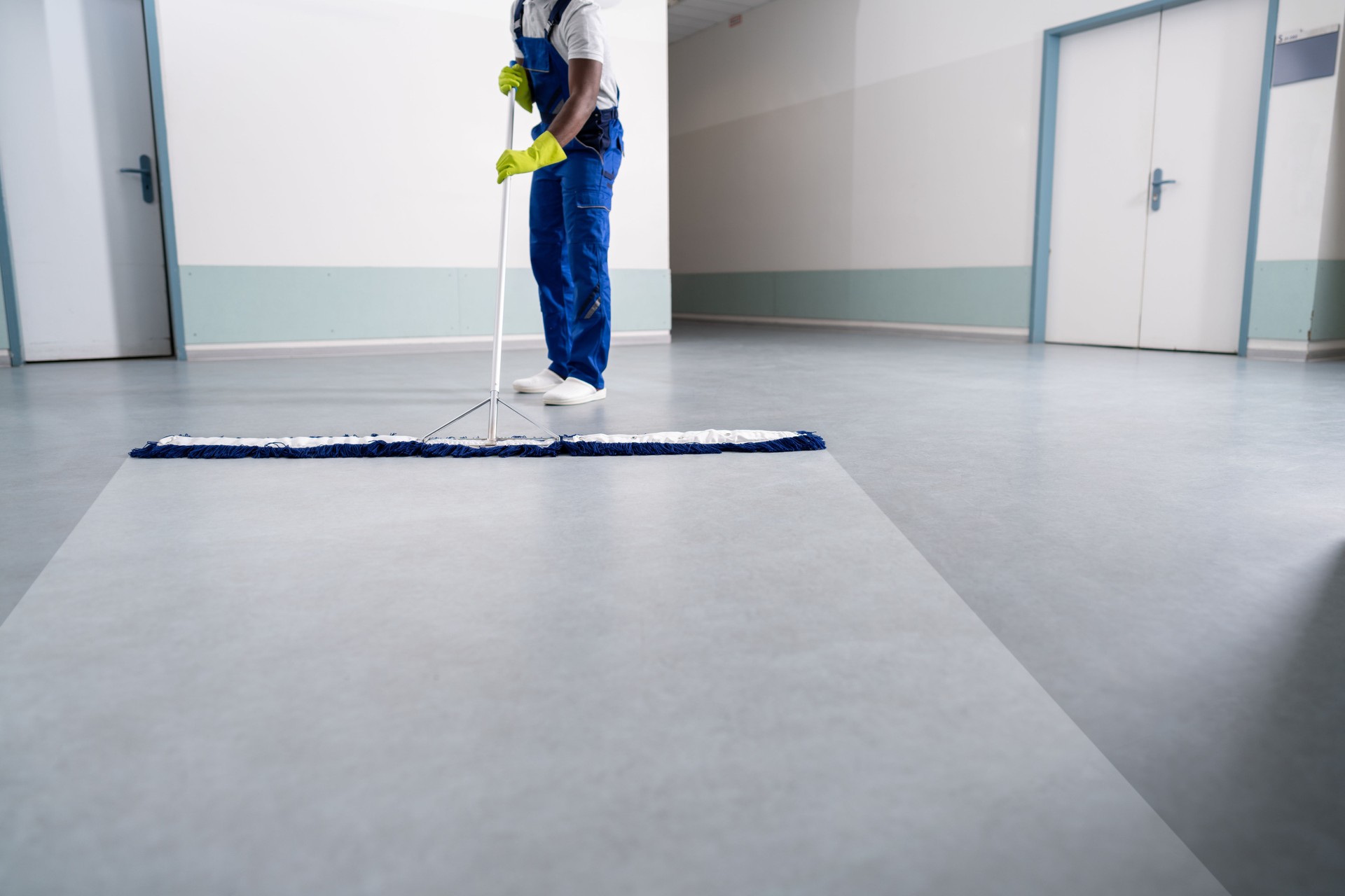 Young Man Cleaning The Floor With Mop